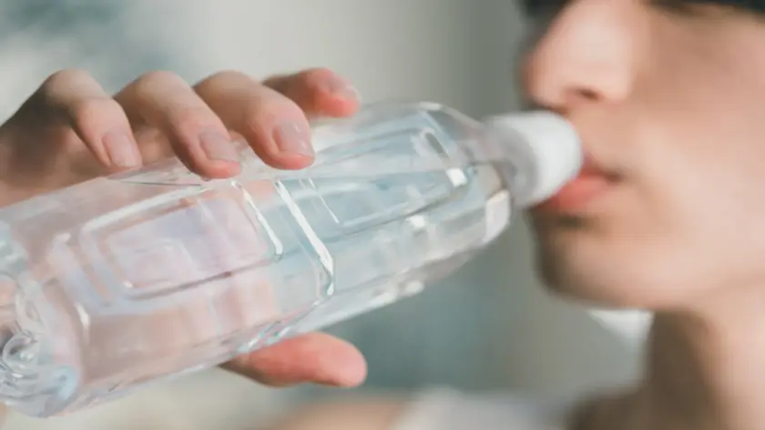喉が渇いてペットボトルの水を飲んでいる人