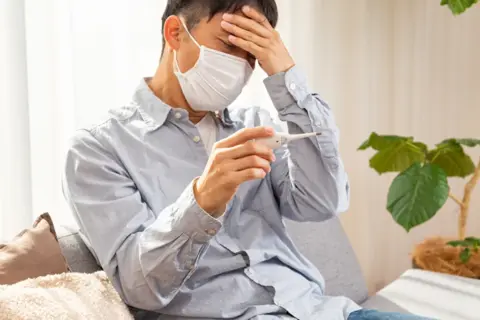 熱を測るマスクをした男性