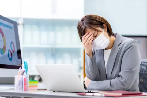 仕事中に体調が優れず辛い女性