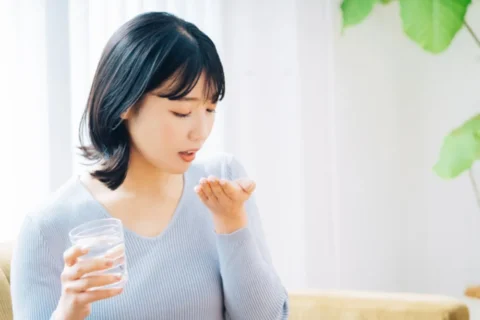 薬を飲む女性