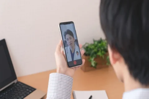 スマホでオンライン診療を受ける男性