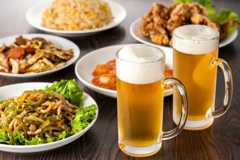 ビールと脂っこいおつまみが並んだテーブル