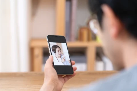 スマートフォンを使ってオンライン診療で下痢の悩みを相談する患者さん