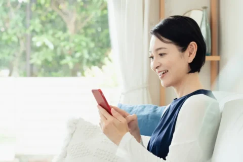 スマホでオンライン診療を受ける中年女性