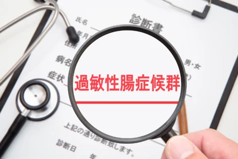 過敏性腸症候群(IBS)について書かれた診断書を拡大鏡で見る