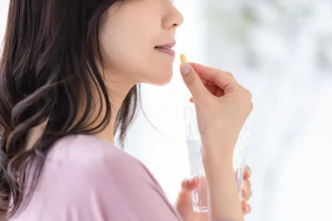 薬を飲む中年女性