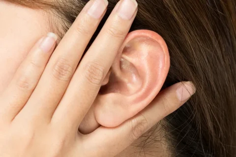 耳のツボを押して頭痛を予防する女性