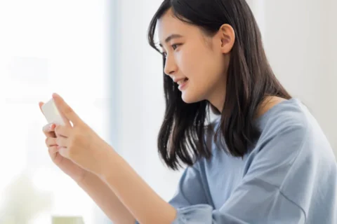 スマホでオンライン診療を受ける女性
