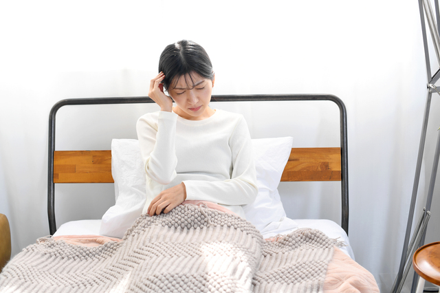 生理中の頭痛に苦しむ女性