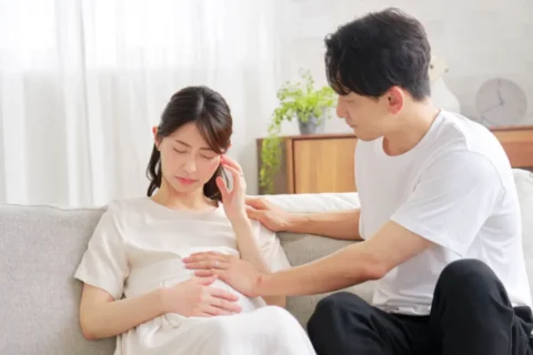 頭痛が辛い妊婦と寄り添う男性