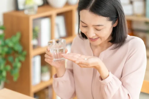 薬を飲む中年女性