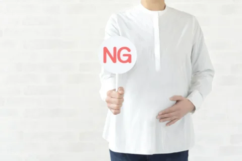 NGの札をもつ妊婦