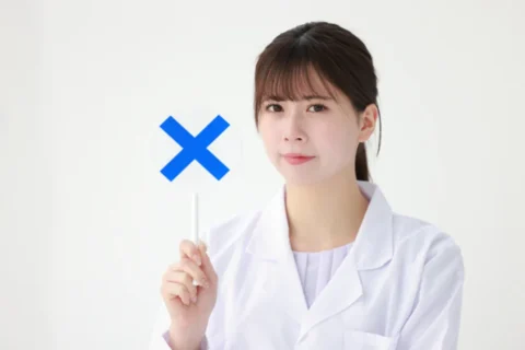 バツの札をもつ医師