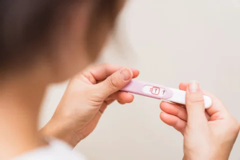 陽性の判定が出ている妊娠薬を持つ女性