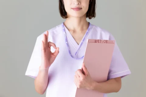 右手でOKサインをする女性の医療従事者