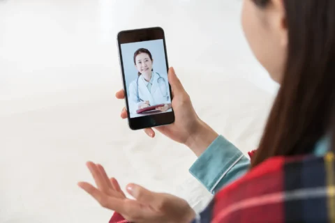 スマホでオンライン診療を受診する女性