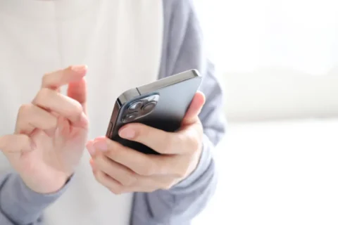 スマホでオンライン予約をする人の手元